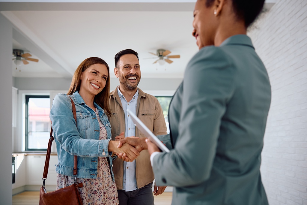 Couple shaking hands with real estate agent